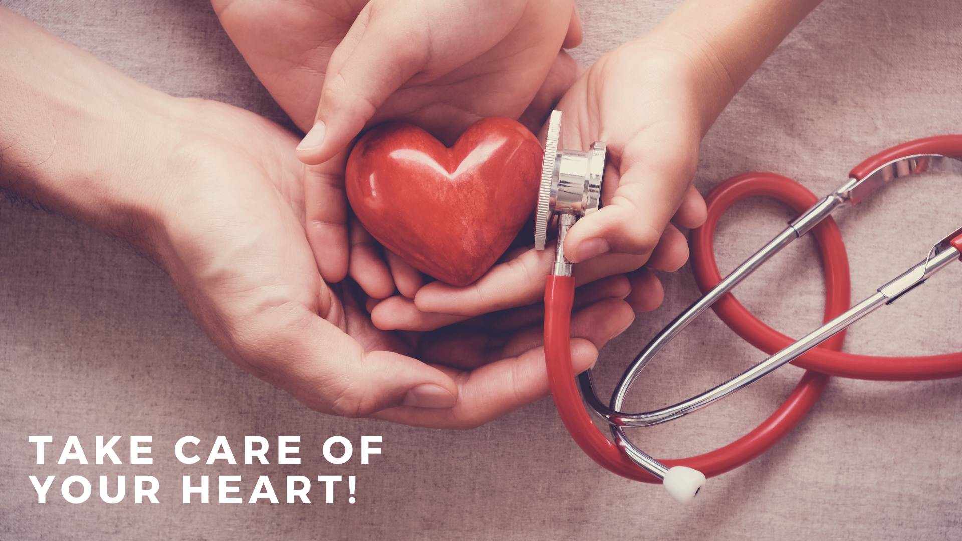 red heart in hands with stethoscope