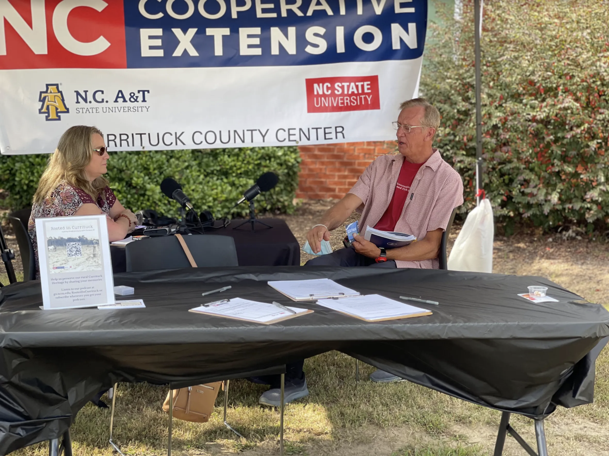 woman interviewing man under tent